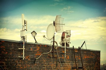 satellite dishes on the roof. Photo toned in yellow