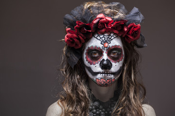 A woman in Halloween costume and skull makeup