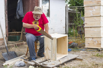 Ukrainian senior carpenter making beehive
