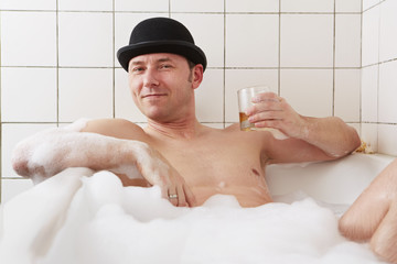 Badewanne, Mann, mit hochgehaltene Whiskexglas