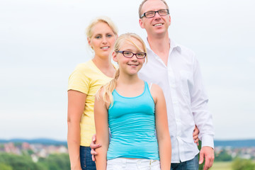 Family standing on grass of lawn or field