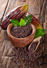 Cocoa pod with bowl on a dark wooden table.
