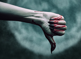 Vampire bloody hand shows thumb down gesture