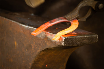 Hammering glowing steel - to strike while the iron is hot.