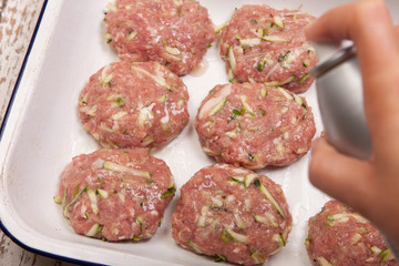 spaying oil on turkey patties