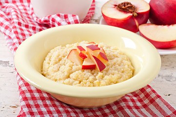 Porridge in a bowl with slices of peach