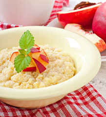 Porridge in a bowl with slices of peach