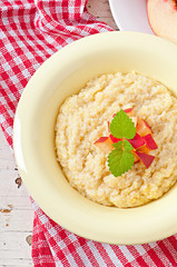 Porridge in a bowl with slices of peach