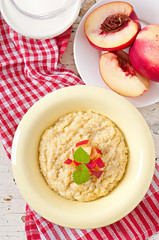 Porridge in a bowl with slices of peach