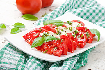 Caprese Salad. Tomato and Mozzarella slices with basil leaves.