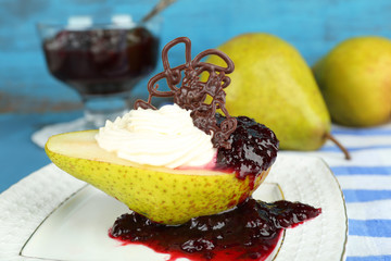Tasty dessert with pear, cream and berry sauce
