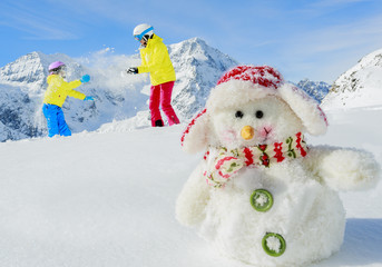 Winter fun, snowman and happy skiers