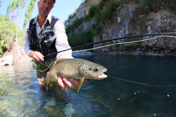 Closeup of fario trout caught in river by fisherman