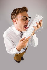 Geeky businessman licking his keyboard
