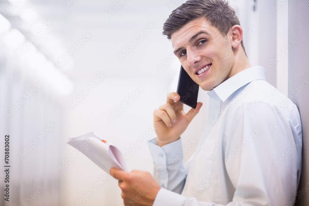 Poster Smiling technician on the phone holding a document