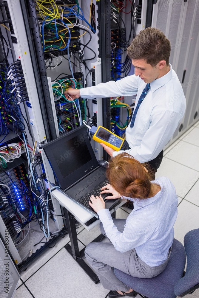 Aufkleber team of technicians using digital cable analyser on servers
