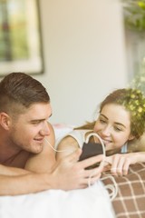 Obraz na płótnie Canvas Cute couple lying on bed listening to music