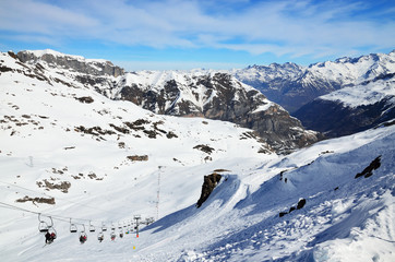 Fototapeta na wymiar Chair lift above the snow slopes