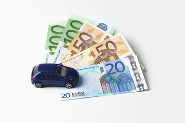 Modellauto und Euroscheine auf weißem Hintergrund