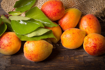 Apricots with sack cloth on wooden table 