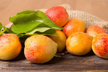 Apricots with sack cloth on wooden table 