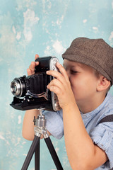 Junge spielt mit nostalgischer Kamera - obrazy, fototapety, plakaty