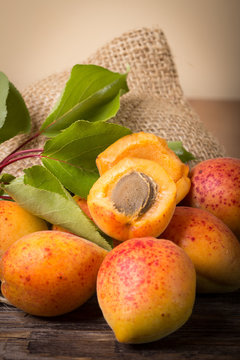 Apricots with sack cloth on wooden table 