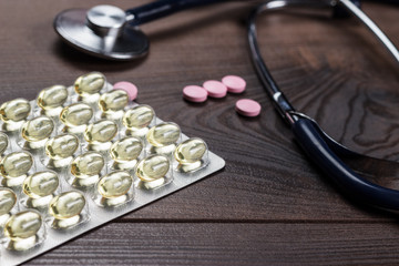 statoscope and pills over wooden table