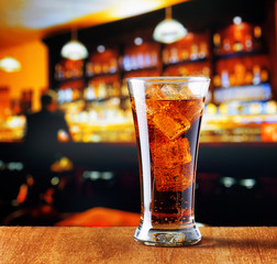 Glass of cola with ice in a bar