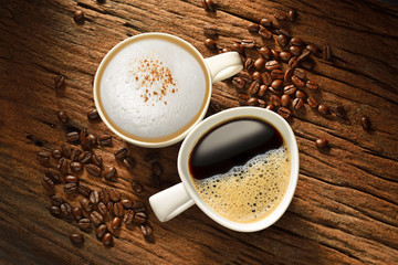 Two cups of coffee and coffee beans on old wooden table