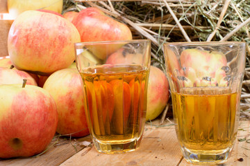 two glasses of cider with some apples