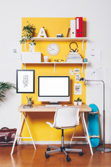 Modern creative workspace on yellow wall.