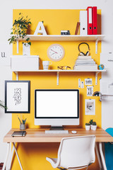 Modern creative workspace on yellow wall.