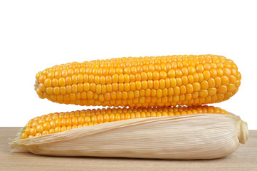 ripe ears of corn on a wooden plank