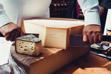 Worker slicing the cheese.  Close up of Cutting cheese.