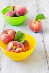 ripe peaches in colored bowls