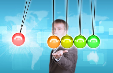 Businessman in suit hold Newtons cradle