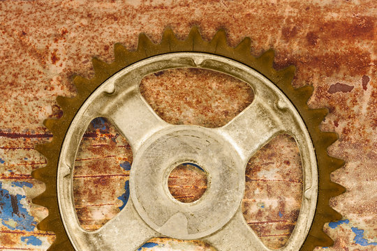 Vintage cog wheel against a rusty background