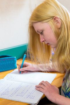 Blonde schoolgirl making homework