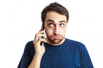 fed-up young man talking on mobile isolated on white