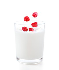 Delicious fresh raspberries falling into glass of yogurt