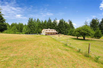 Obraz premium Large farm field with empty horse barn
