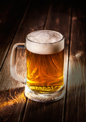 mug of beer on wooden background