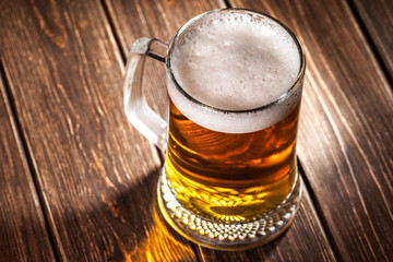 mug of beer on wooden background