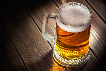 mug of beer on wooden background