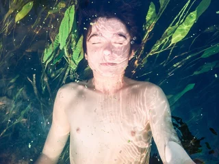 Tuinposter Boy submerged in a pure river © Przemek Klos