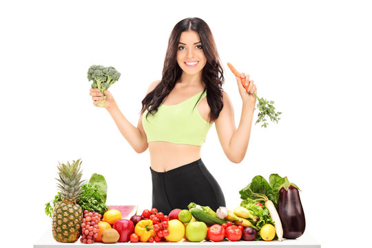 Woman behind table full of fruits and vegetables