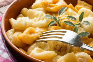Gnocchi di ricotta e di zucca misti nel tegame di coccio