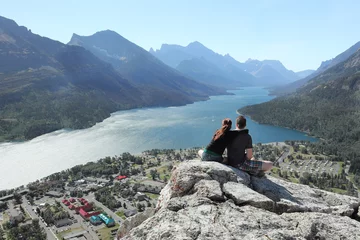 Foto op Canvas Couple Looking Out Over a Town and a Mountain Lake Below © Brian Lasenby