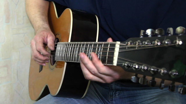 performer playing on the acoustic guitar.